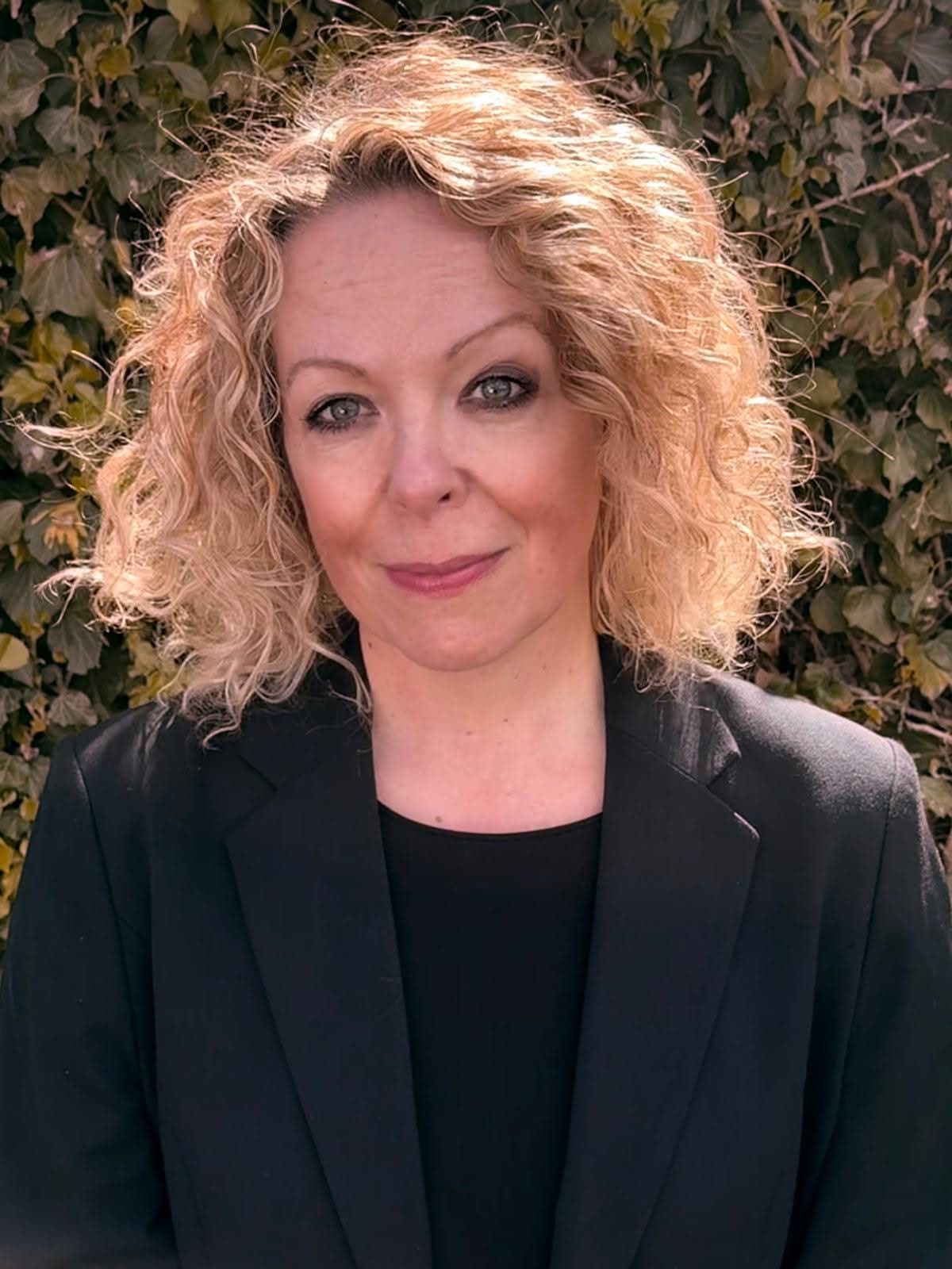 Clare in dark clothing, suitable for funeral ceremony work.